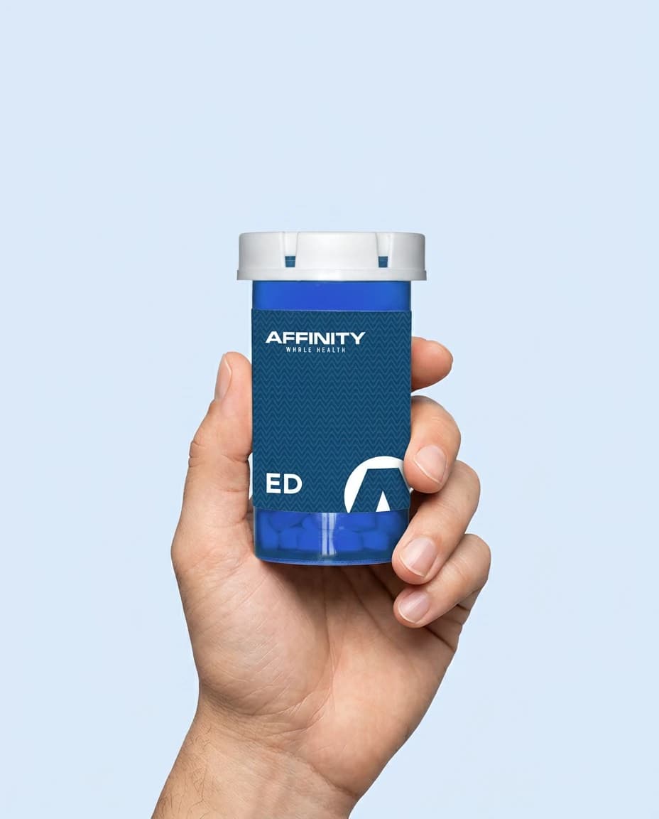 A hand holding an Affinity ED treatment bottle